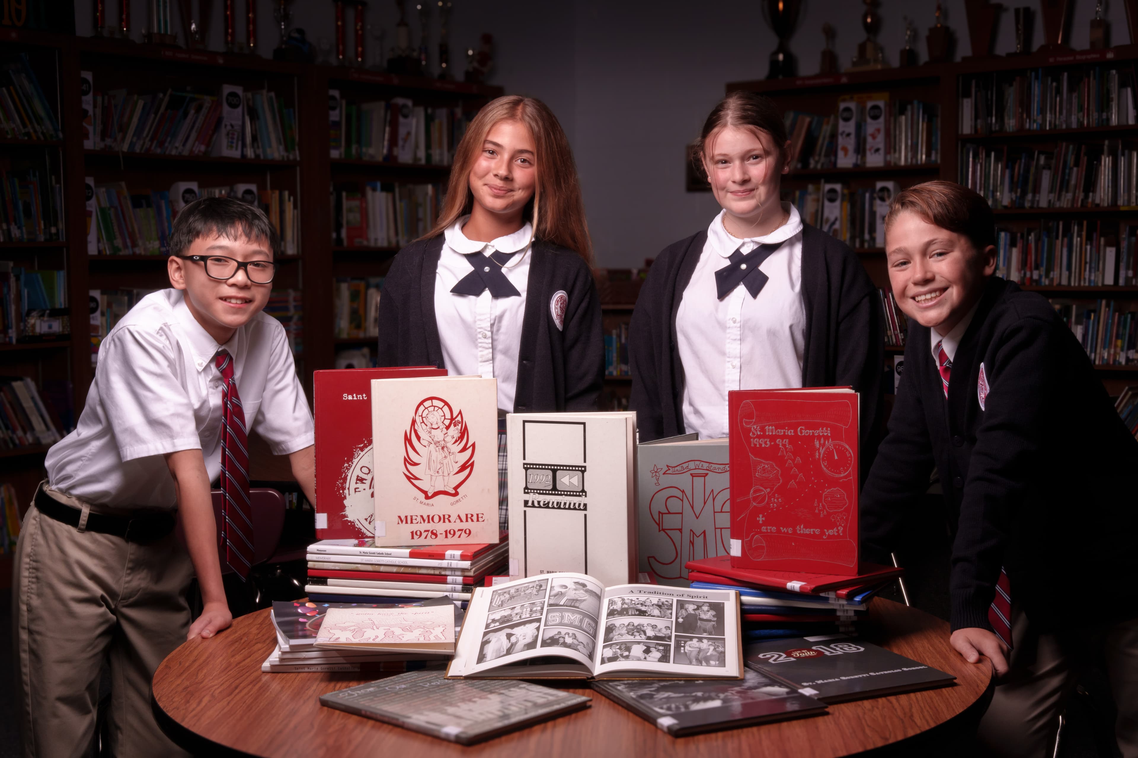 Saint Maria Goretti Catholic School students with yearbooks in the school library